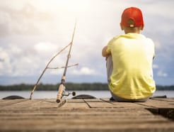 boy fishing on a pier