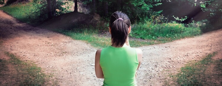 woman standing at a fork in the road, indecisive