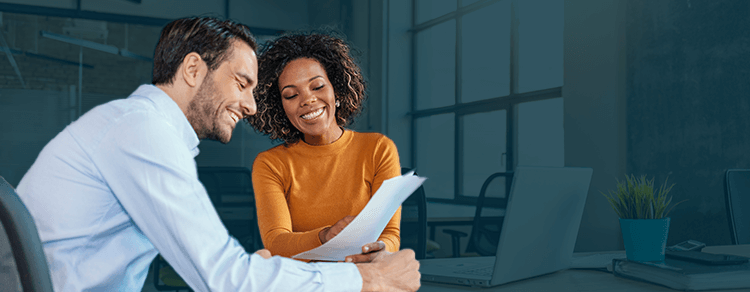 white man and dark-skinned woman smiling in office