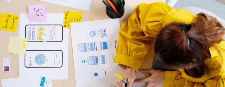 designer in yellow smock surrounded by wireframes