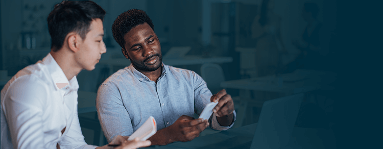 Asian man and Black man looking at smartphone