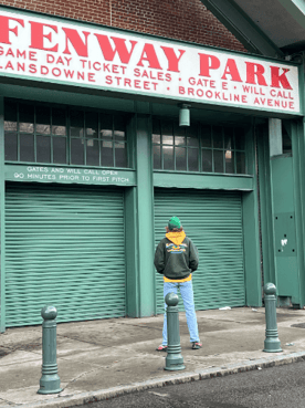 teen standing in front of Fenway Park sign